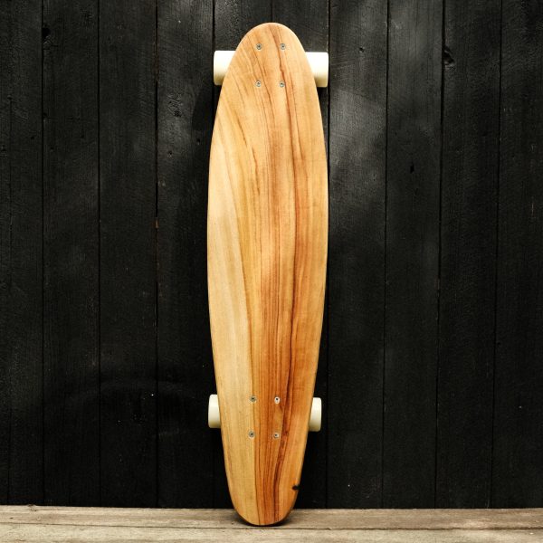 Front of a longboard skateboard with trucks and wheels in white